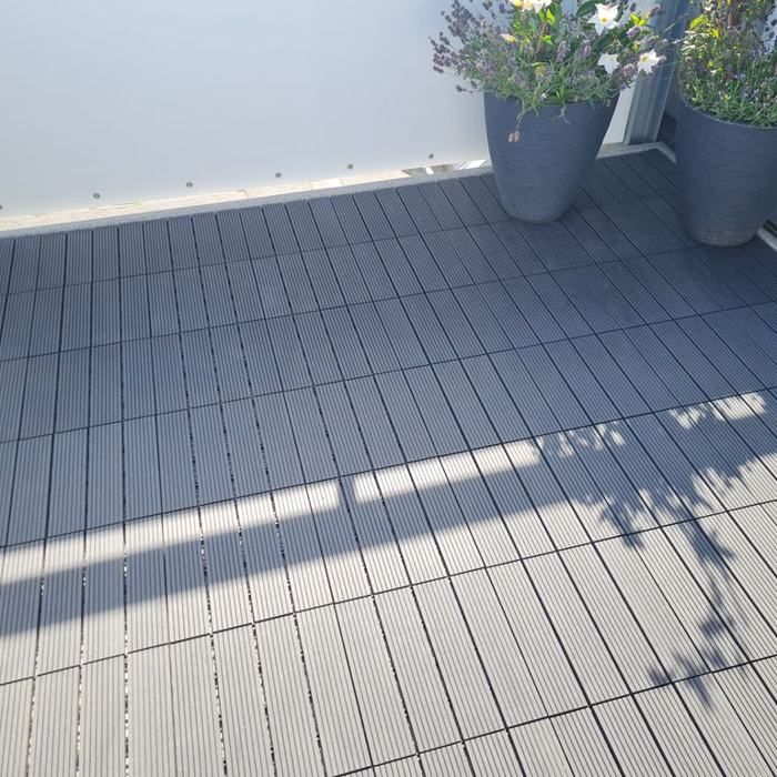 Balkon mit grauen Klickfliesen in der Sonne